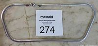 Photo showing the full 20 inch silver chain necklace laid flat with auction lot number card.