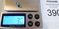 Digital scale showing combined carat weight of 3.0 for the gemstones.