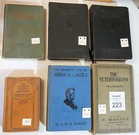 Six antique hardcover books displayed in two rows, showing front covers and date stickers.