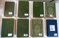 Top view of 8 antique books laid flat showing covers, dates visible on some covers from 1901 to 1923.