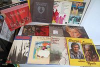 Photo showing 12 vinyl record albums arranged together, titles visible, various artists and genres seen such as Rod Stewart, Tammy Wynette, Diana Ross, and show soundtracks.