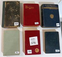 Top view of six antique books with varying colors and condition showing dates stickers