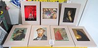 Seven art prints, each in a beige protective folder, showing reproductions of various classic artworks including portraits, figures and objects.