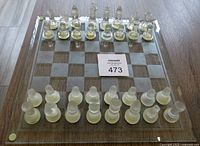 Full view of the chessboard with clear and frosted crystal chess pieces arranged setup.