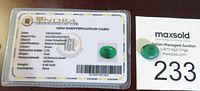 Photo of the natural emerald gemstone alongside the JGL gem identification card certifying it as a natural emerald, including measurements, weight, color, and refractive index.