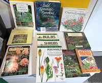 Photo shows 10 vintage gardening and plant books arranged on a white surface with yellow and white backgrounds. Titles focus on garden design, plant types, and pest control.