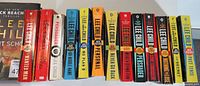 Photo showing the full lineup of Jack Reacher books by Lee Child with colorful spines in used condition.