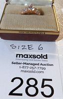 Photo showing the ring in its box with the auction label indicating size 6
