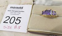 Photo of the ring with auction tag showing size 8.5 on a soft ring cushion
