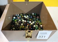 Photo showing the open metal box filled with various colorful vintage marbles.