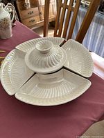 Pearl white 6 piece Lazy Susan server set assembled with central bowl and four segmented plates on a Lazy Susan base on a dining table.