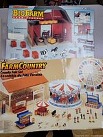 Photo of Big Farm Barn Playset and FarmCountry County Fair Set box images showing toy components and layout.