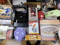 Overview of kitchen and home items including steam cleaner, induction cooktop, baking stone, heater fan, waffle maker, and containers.