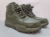 Side view of the boots showing overall condition and design with Nike swoosh visible