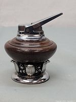 Side view showing wooden rounded body with decorative chrome base and a long chrome ignition arm.