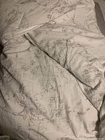 Photo of floral patterned side of reversible comforter in neutral tones.