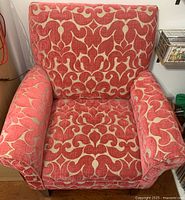 Front view of the large armchair showing pink fabric with tan pattern, arms and back cushions.