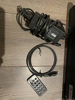 Power adapter, remote control, and connection cable for the Play Station 3 sound bar.