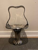Full view of the vintage silver basket standing upright showing height, handle shape, and flared base