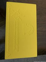 Close-up photo of the yellow thoracic retrainer foam device showing embossed logo and text