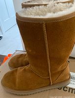 Side view of tan mid-calf Ugg Koolaburra boot showing suede material and stitching.