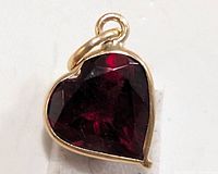 Close-up front view of heart-shaped garnet pendant in 10KT gold.