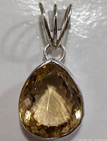 Close-up front view of the faceted teardrop citrine in silver setting.