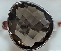 Close-up front view of faceted pear-shaped smokey quartz set in silver bezel ring