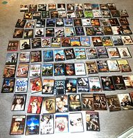Wide angle shot of assorted DVDs laid out on floor, showing covers of various movies and TV shows.