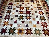 Full view of quilt laid out flat showing star block pattern and overall condition