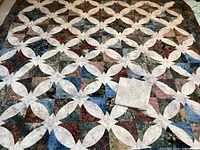 Full quilt top with one pillowcase folded on surface