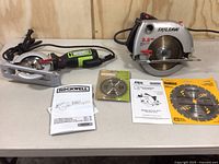 Photo showing Rockwell compact circular saw, Skil saw, extra blades and manuals on table
