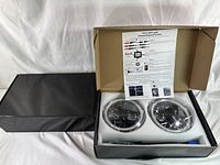 Two round black Jeep RGB LED headlights with halo ring in original packaging with connecting instructions sheet visible.