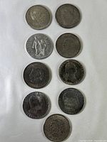 Full lineup of nine vintage collectible coins arranged in rows on a white background showing obverse sides with various portrait and emblem designs.