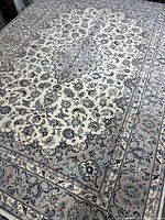 Full view of rug laid flat showing central medallion and border pattern