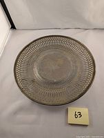 Top view showing plate with central engraved monogram and reticulated gallery rim