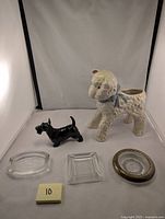 Photo showing all items in the lot: Royal Doulton black Scottie dog figurine, white and blue Hull lamb planter, glass coaster with metallic rim, and two clear glass ashtrays.