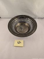 Angled top view showing overall shape, pierced border and monogram.