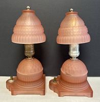 Pair of antique Art Deco pink glass table lamps with textured stepped design on base and shade, showing front view