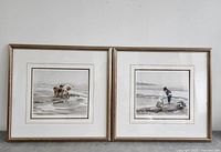 Pair of framed prints by Paul Rupert showing children playing on a beach, hung on wall.
