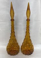 Front view of both decanters with stoppers in place against neutral backdrop