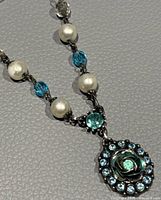 Close-up of rose motif pendant and surrounding blue crystals