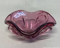 Angled side view showing organic curved shape and rich amethyst color of the thick Murano style glass bowl.