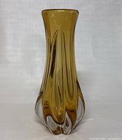 Front view of amber hand blown art glass vase showing flared top and clear bulbous base.