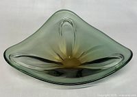 Front view of the shallow bowl showing its triangular shape with three rounded corners and the amber to green color gradient.