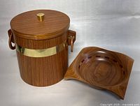 Photo showing teak ice bucket with lid and brass band next to the handcrafted wooden bowl.