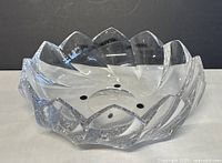 Top angled view showing the interior and the scalloped, petal-shaped edges of the bowl with reflective glass surface.