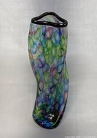 Front angled view showing the colorful pattern and silver plated rim with wavy top edge.