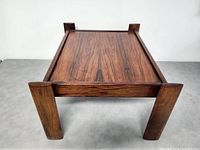 Top front view showing coffee table top's wood grain and sturdy legs.