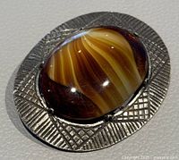 Front angle showing the tiger's eye cabochon with textured metal setting.